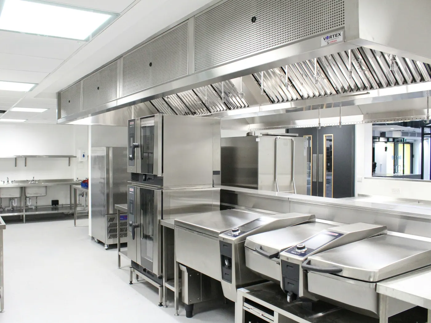 A commercial kitchen with combi ovens, tilting bratt pans and stainless worktops